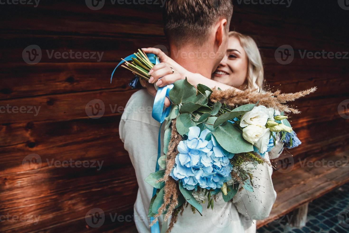 Married couple embracing with bouquet photo