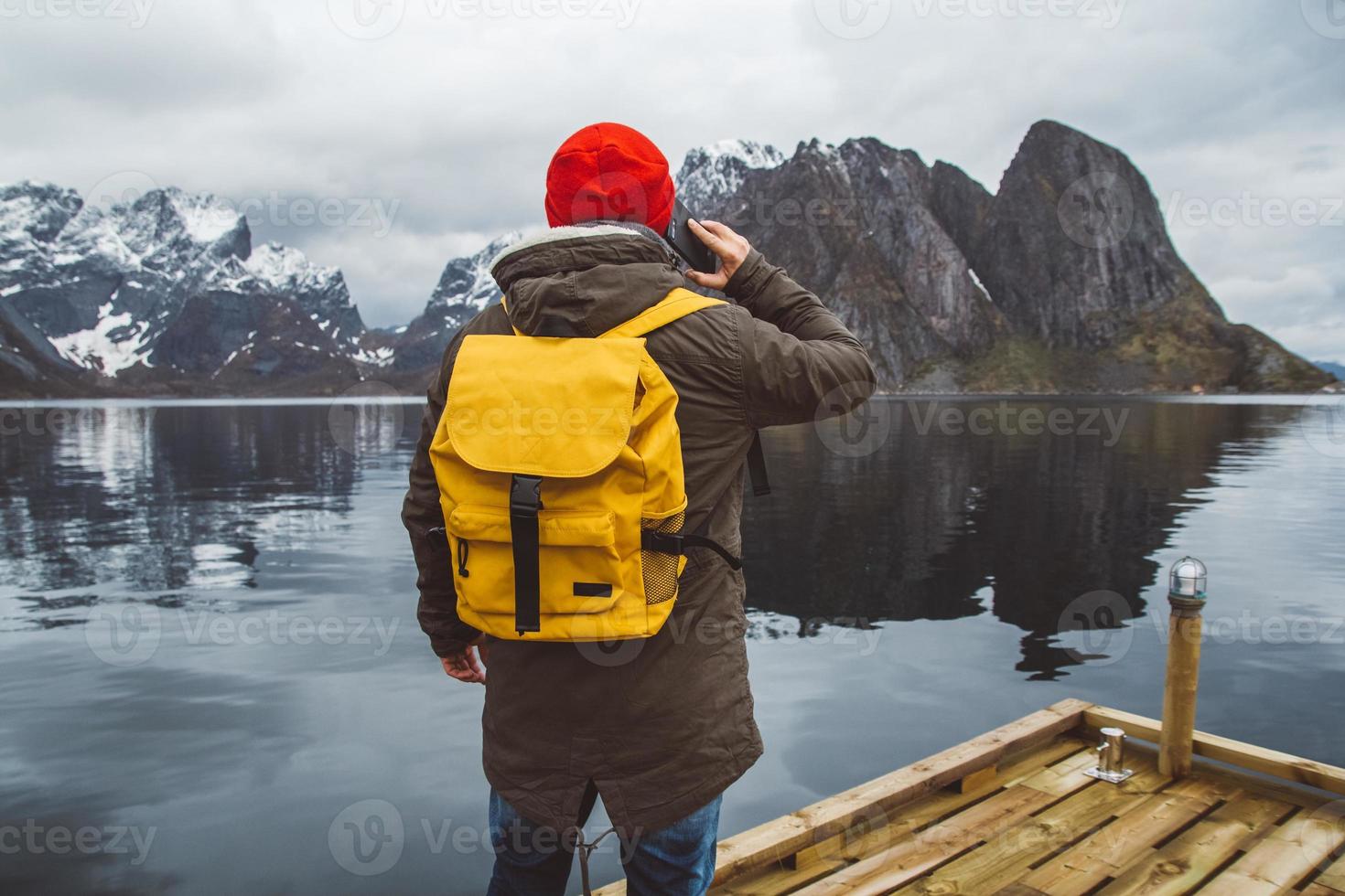 hombre hablando por teléfono con una mochila en la naturaleza foto