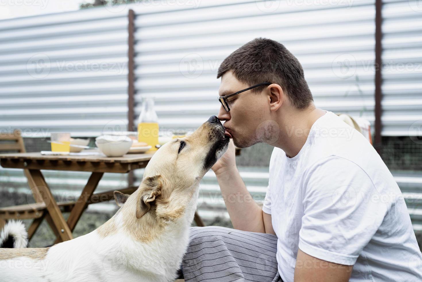 hombre caucásico, besar, un, perro, ambulante, aire libre foto