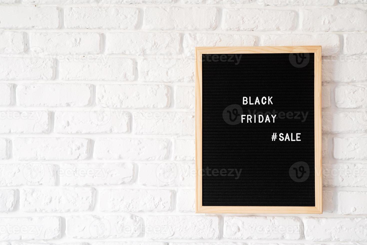 Text black friday sale on black letter board on white brick wall photo