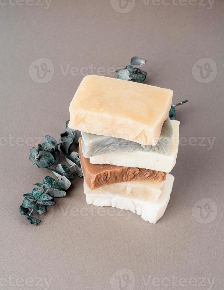 Stack of hand made soap and eucalyptus on gray background photo