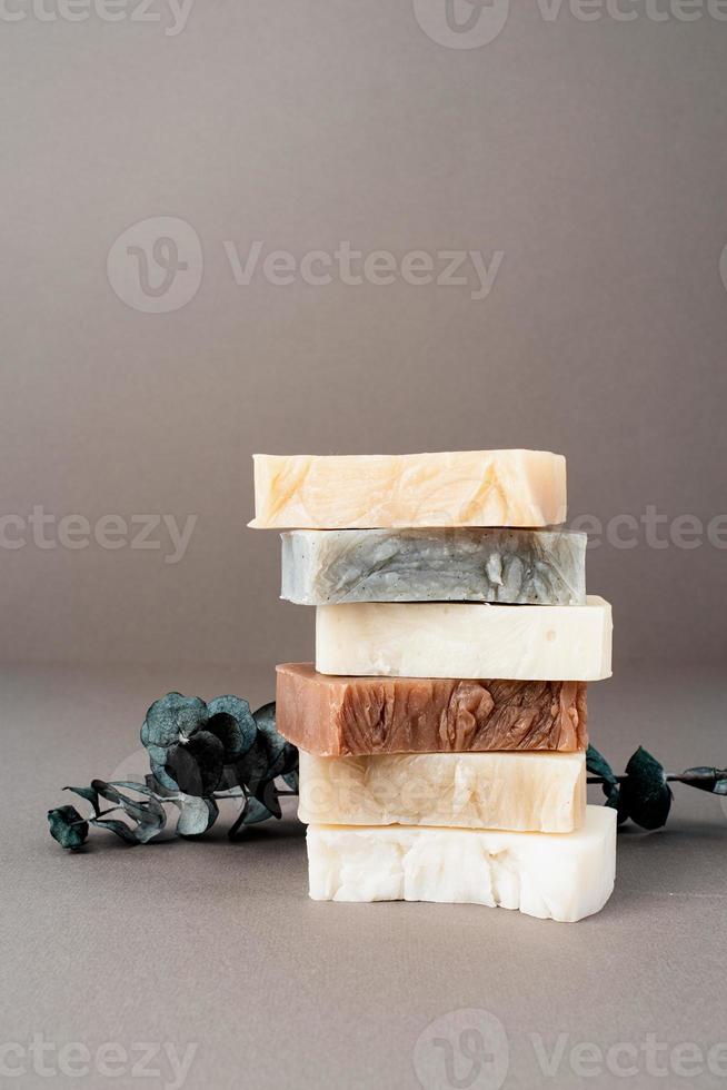 Stack of hand made soap and eucalyptus on gray background photo