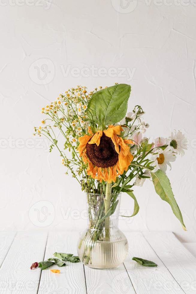 Un ramo de flores secas marchitas en un jarrón sobre blanco foto