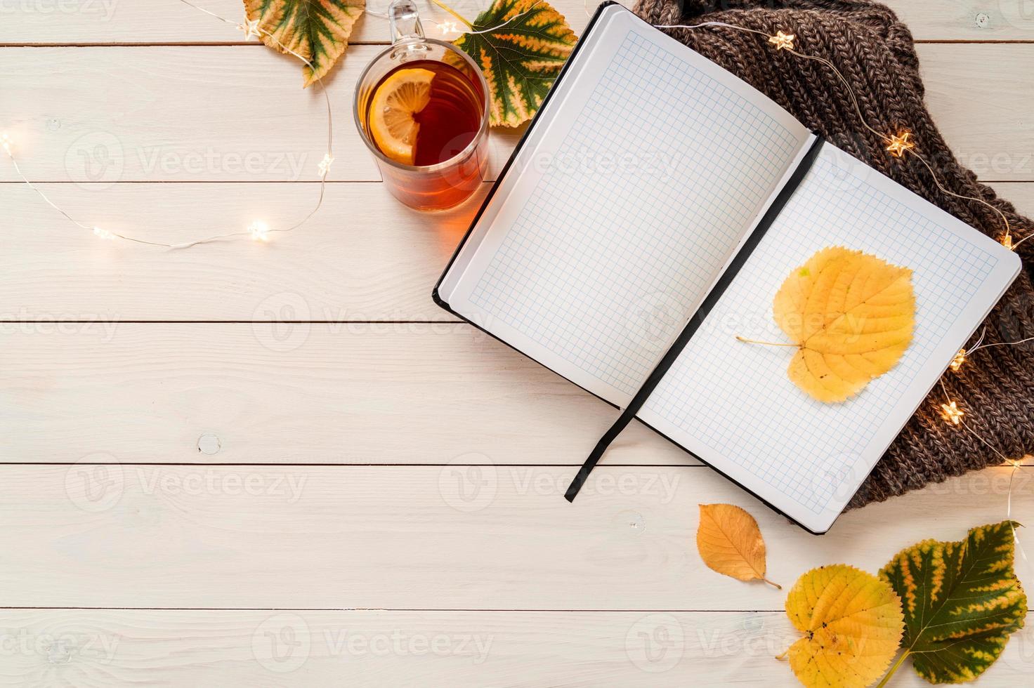 Workspace with notebook, cup of lemon tea photo