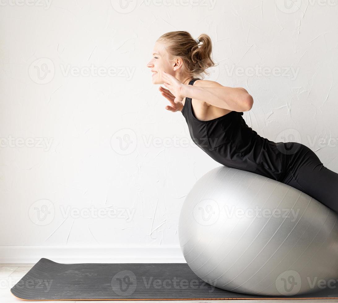 Joven deportista trabajando en la pelota de fitness foto