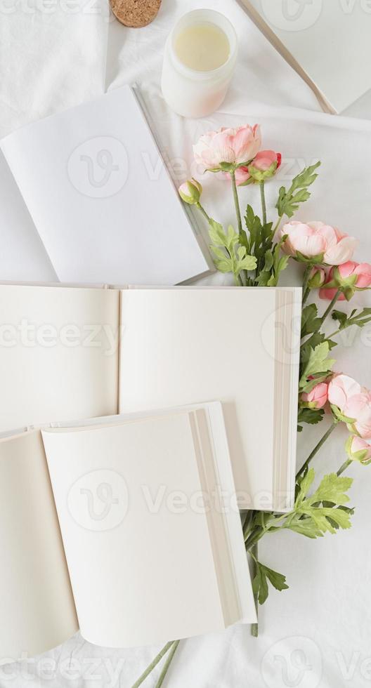 libros abiertos y vista superior de flores en la cama blanca. maqueta de diseño foto