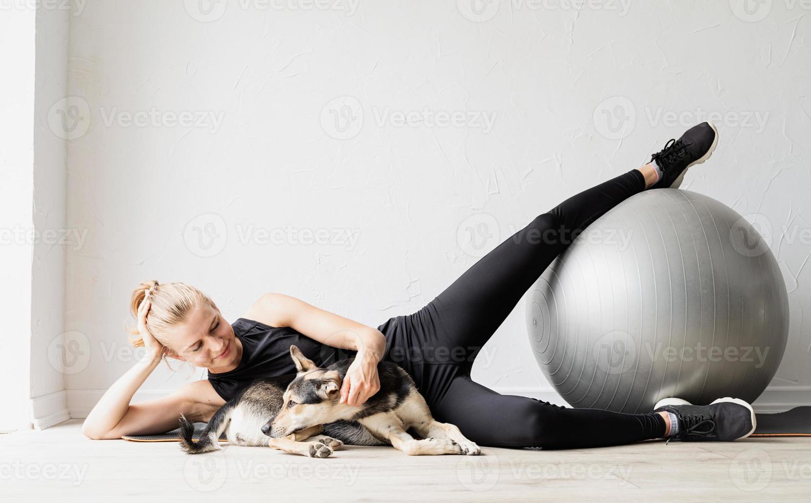 Joven deportista trabajando en la pelota de fitness en casa foto