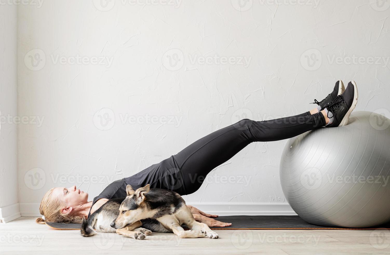 Joven deportista en la pelota de fitness calentando antes del entrenamiento foto