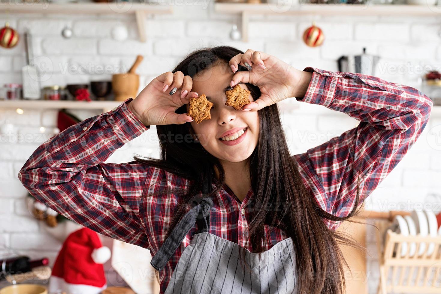 Mujer en delantal sosteniendo galletas en forma de estrella foto