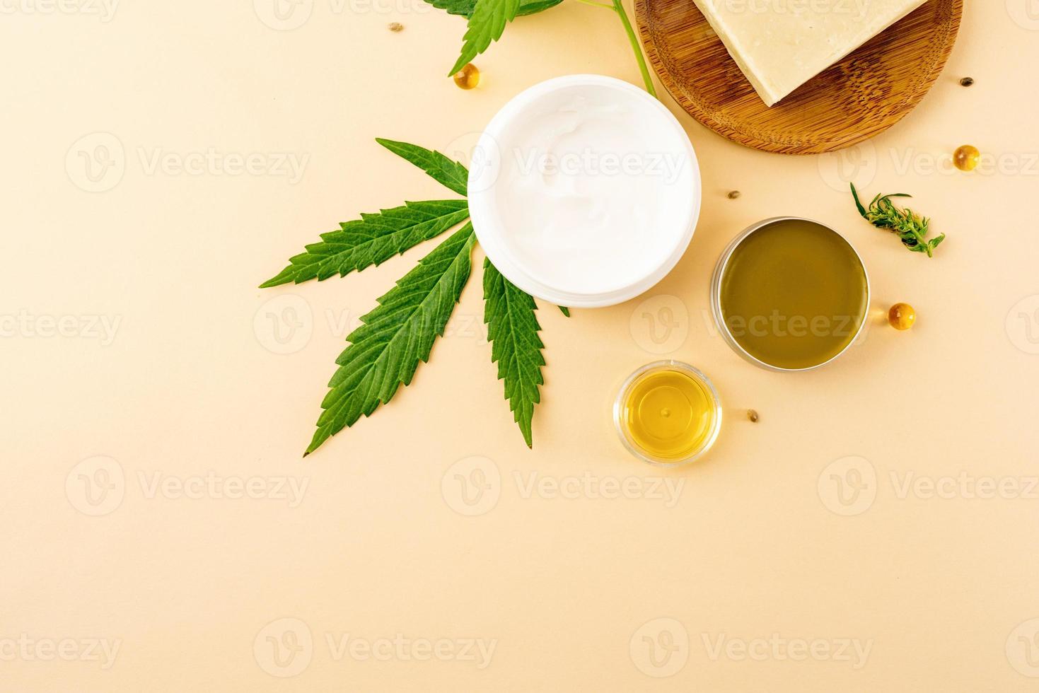 El aceite de cbd y el cannabis deja la vista superior de los cosméticos sobre fondo naranja foto