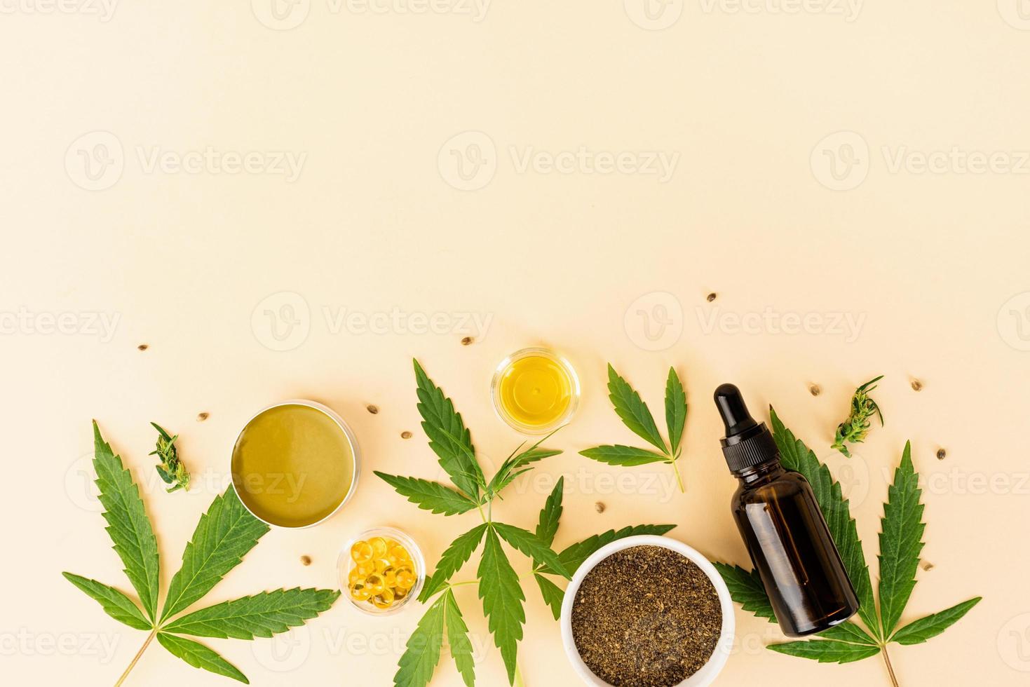 Cbd oil and cannabis leaves cosmetics top view on orange background photo