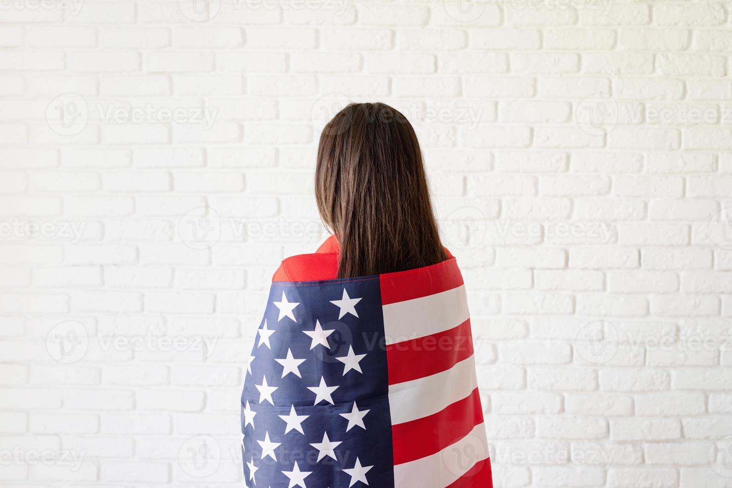 Beautiful young woman with American flag, rear view photo