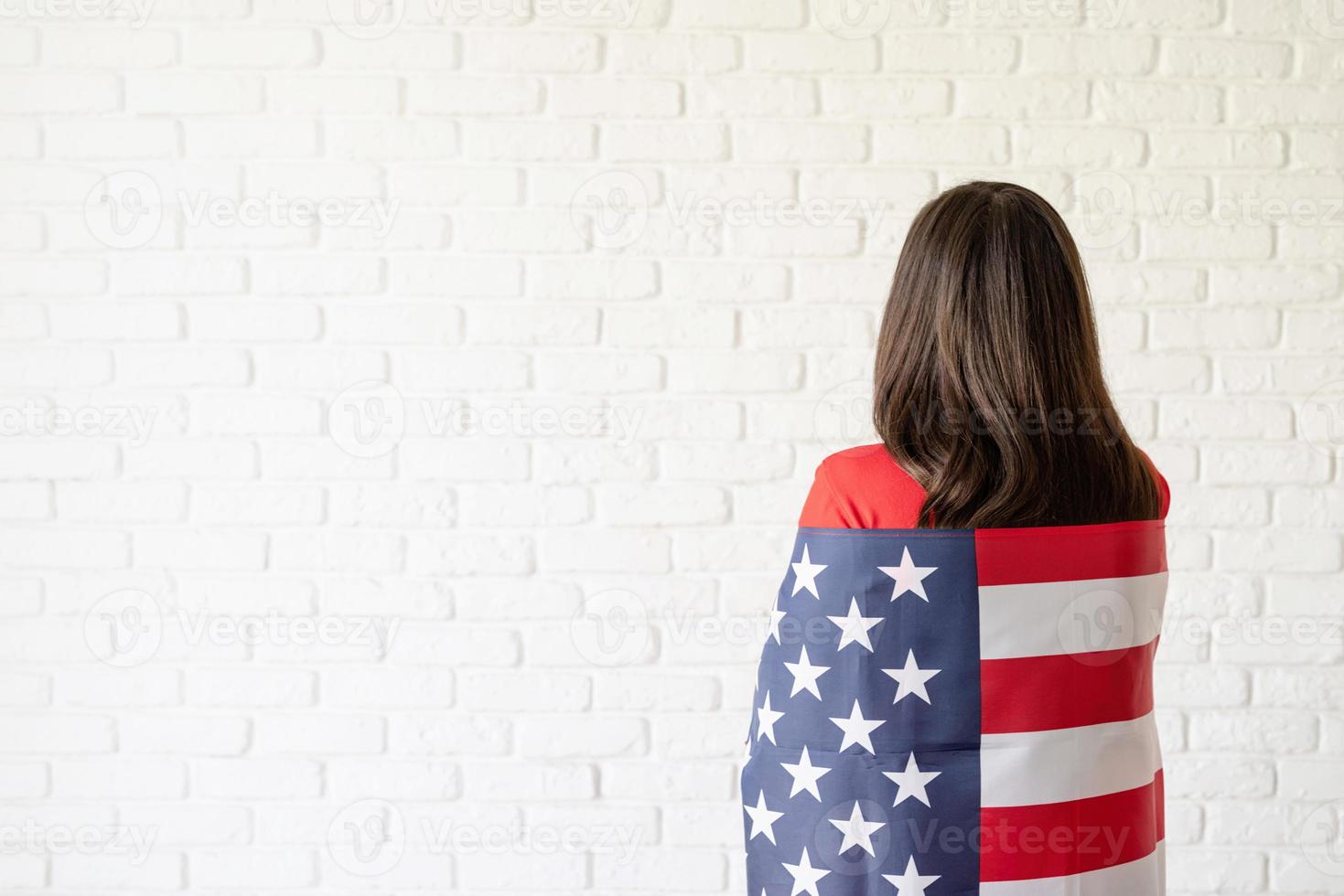 Beautiful young woman with American flag, rear view photo