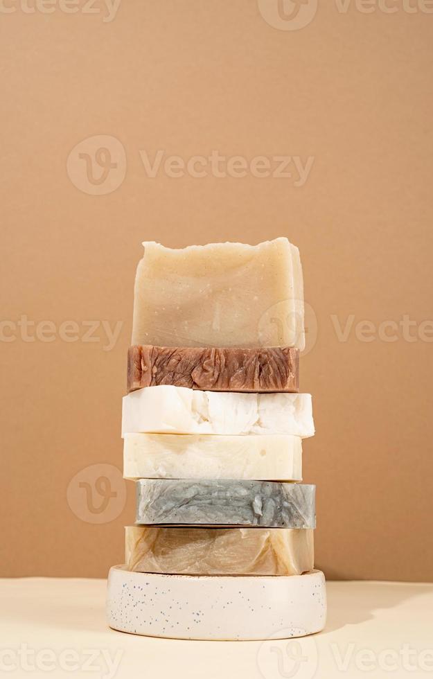 Tower stack of different handmade soaps on cream background photo