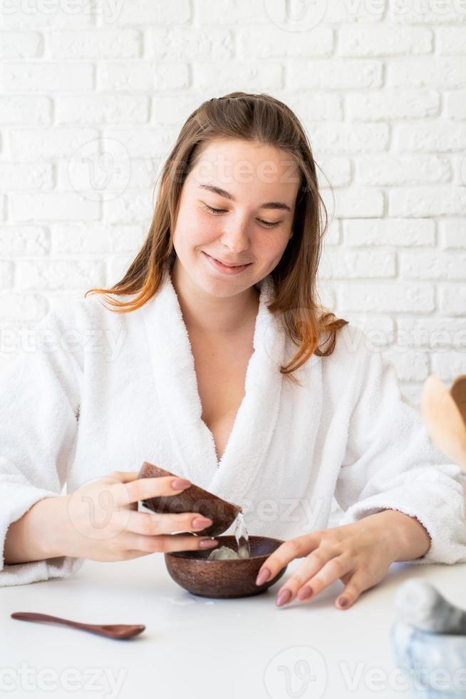 Woman wearing bathrobes doing spa procedures using natural cosmetics photo