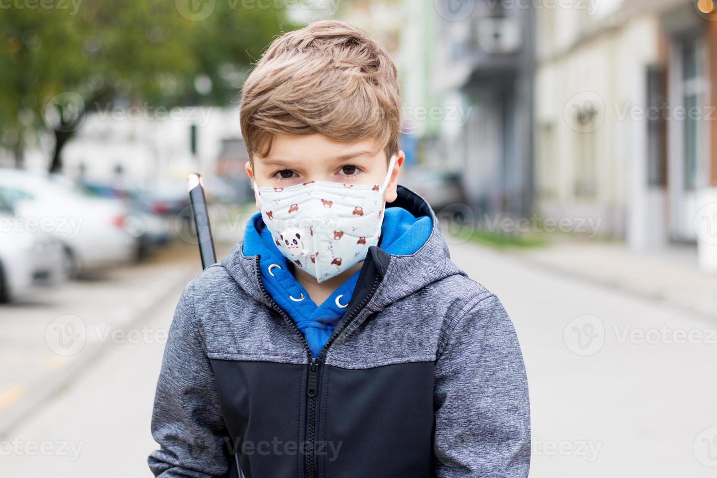 Retrato de un niño con mascarilla protectora en las calles de la ciudad. foto