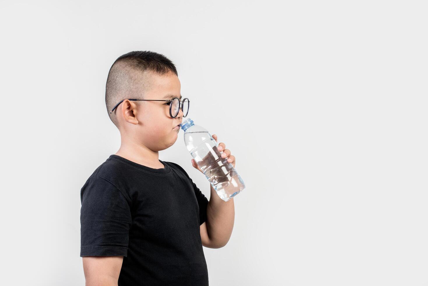 Funny boy with water bottle in studio shot photo