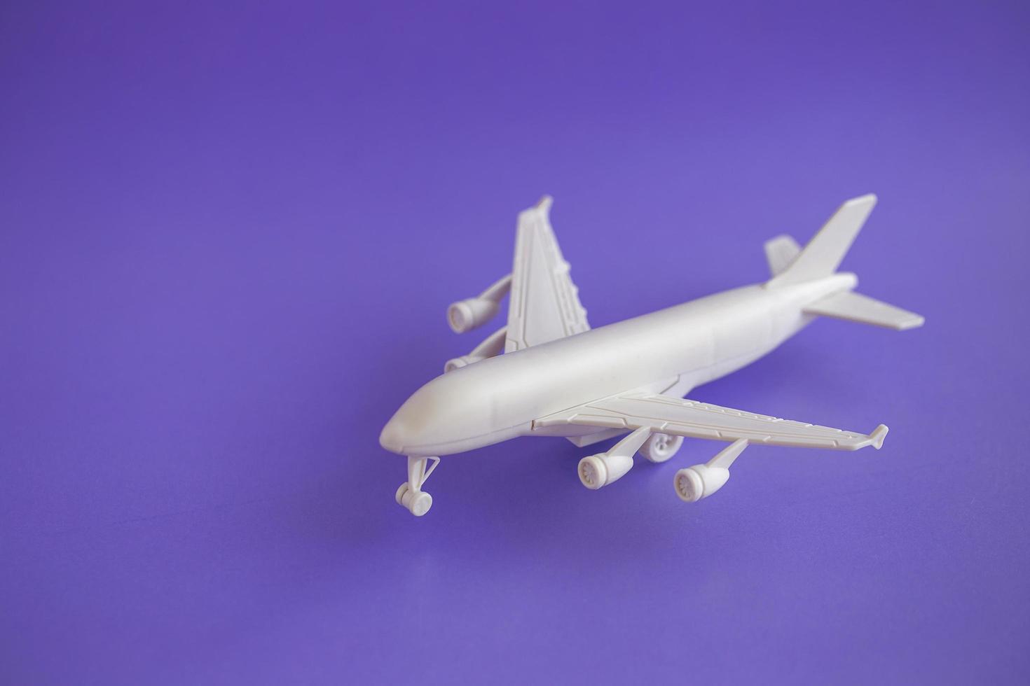 Plastic toy airplane on a violet Background and copy space photo