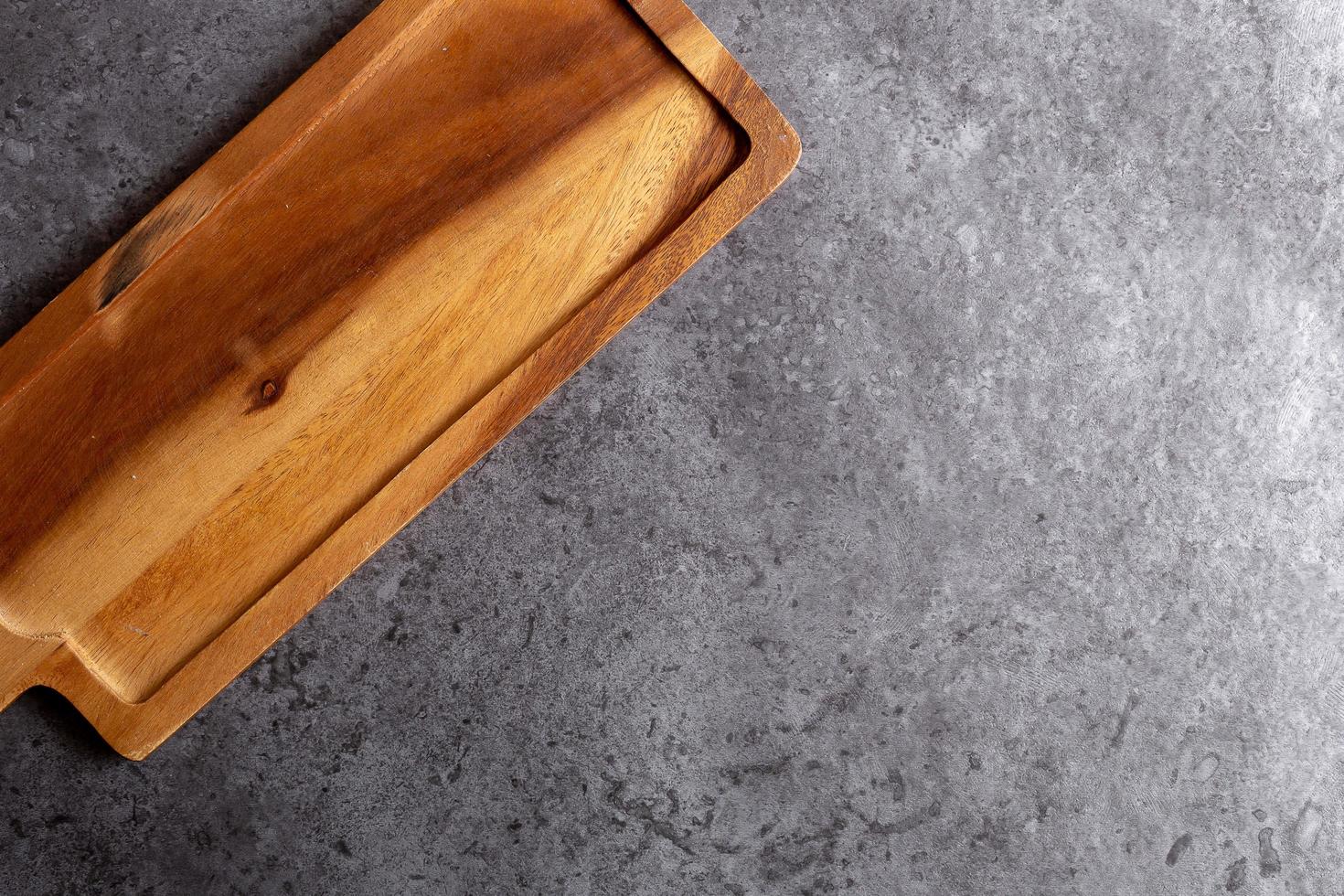 Tabla de cortar de madera sobre fondo de mesa negro foto