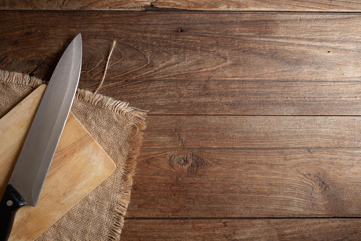 Textura de mesa de madera vieja oscura y vista superior del cuchillo. foto