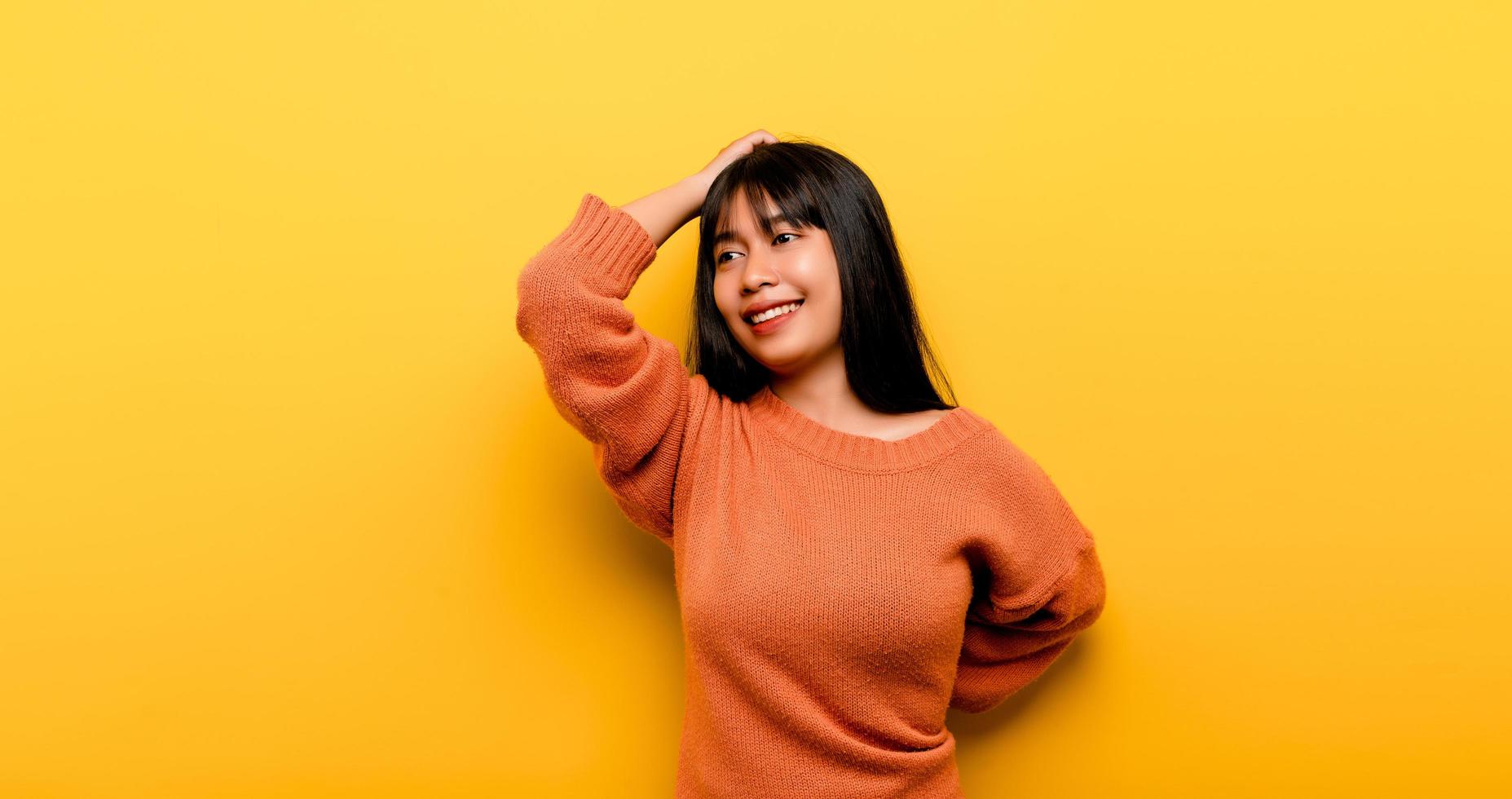 Cute Asian girl smiling on yellow background photo