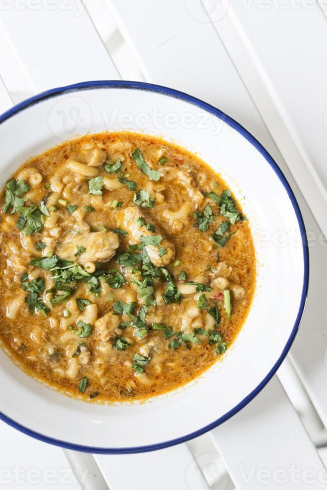 Creamy spicy seafood fish soup with coriander herbs photo
