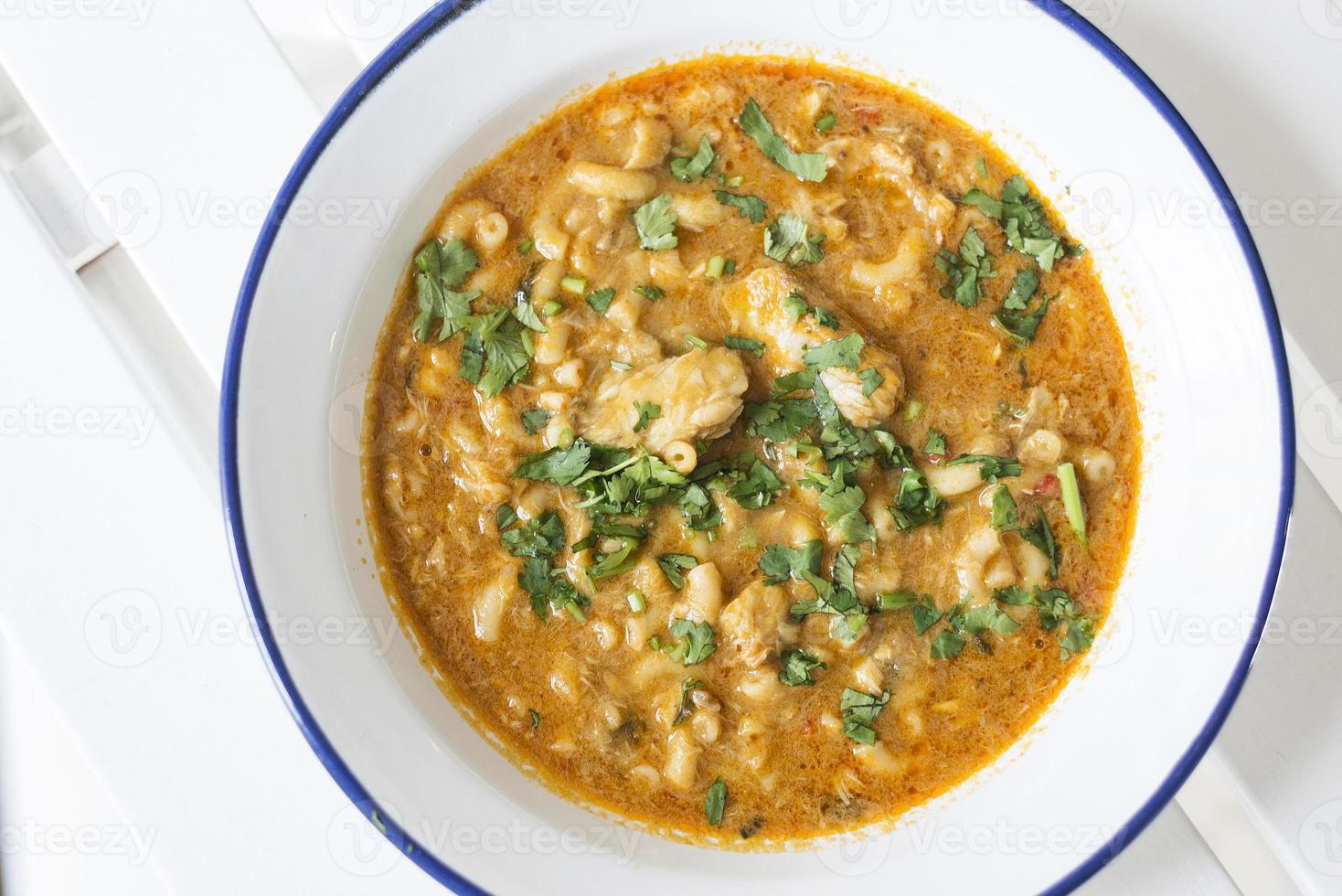 cremosa sopa picante de pescado y marisco con hierbas de cilantro foto