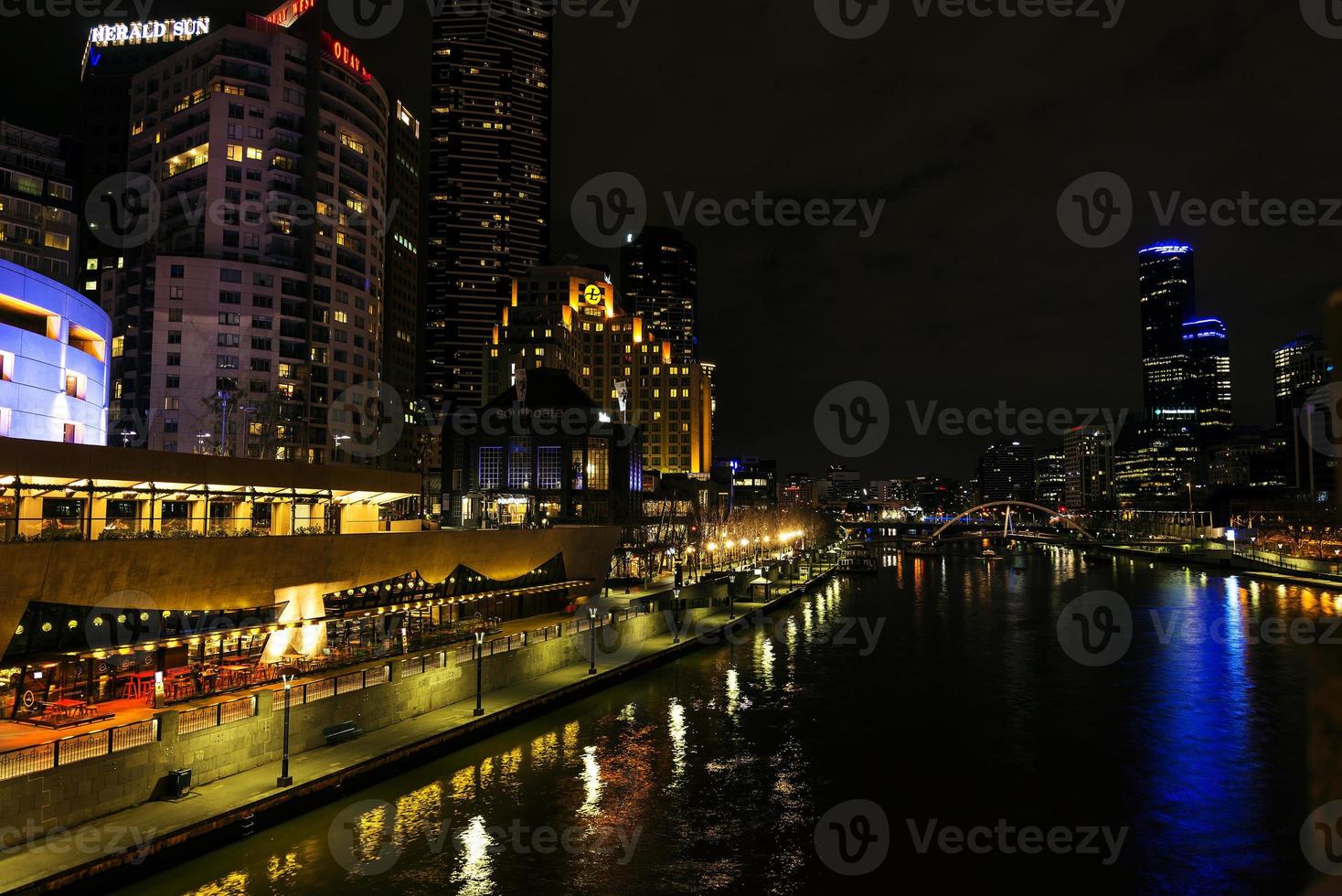 El centro de la ciudad de Melbourne al lado del río horizonte urbano moderno por la noche en Australia foto