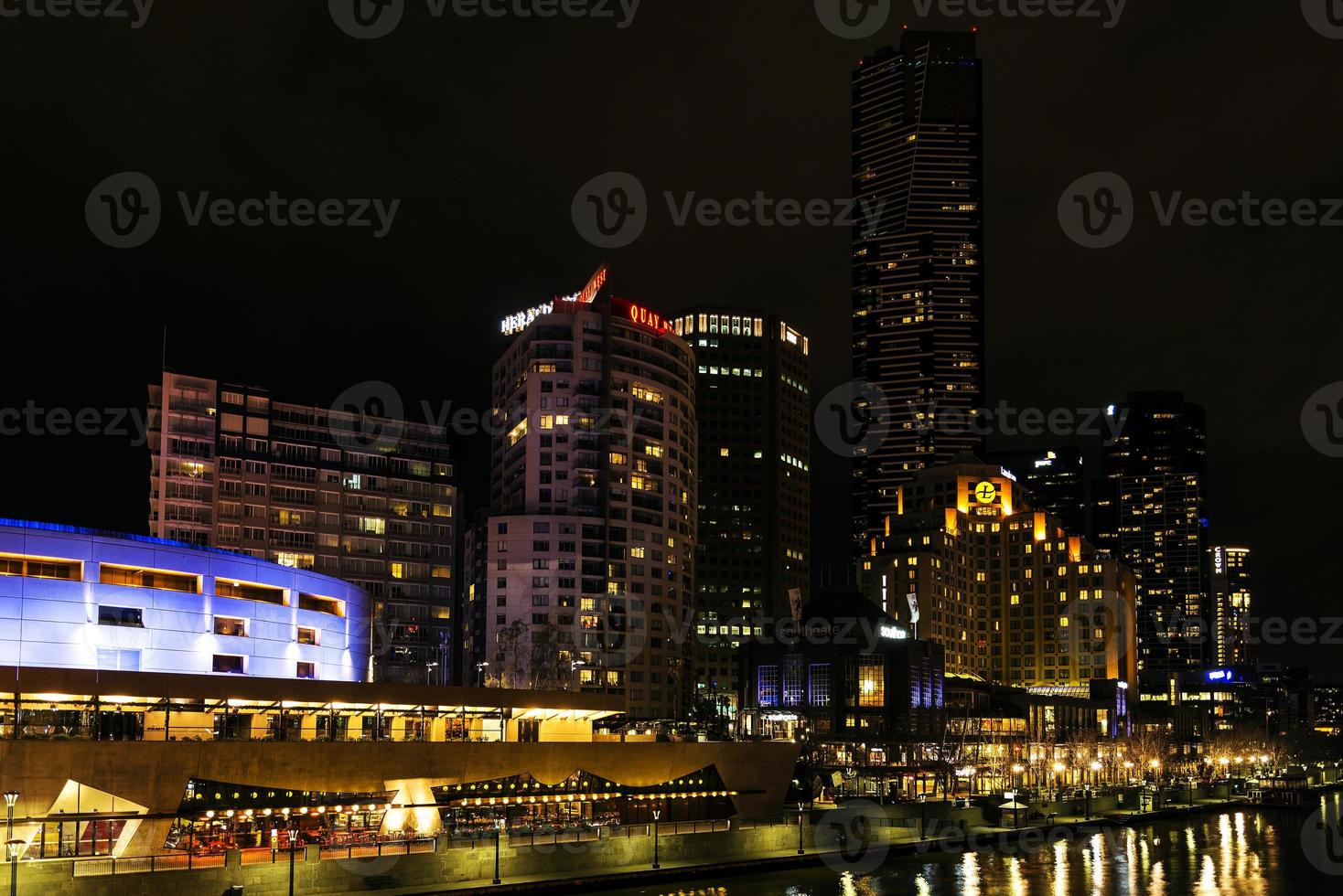 El centro de la ciudad de Melbourne al lado del río horizonte urbano moderno por la noche en Australia foto