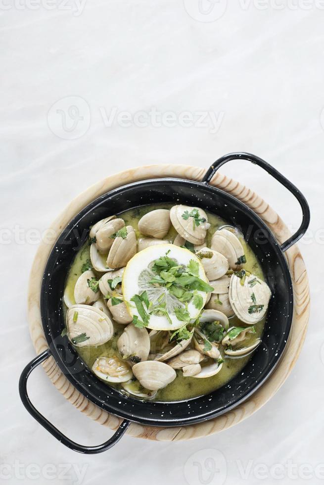 Almejas guisadas portuguesas al ajillo y salsa de marisco al vino blanco foto