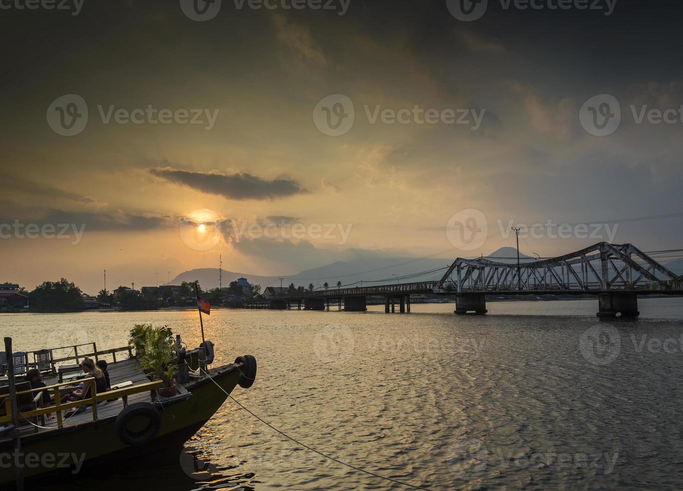 Hito antiguo puente y río al atardecer en Kampot, Camboya foto