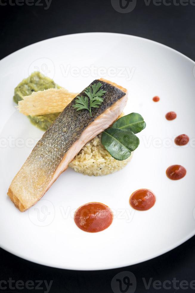 Gourmet fusion cuisine salmon fish fillet with guacamole and turmeric rice meal photo