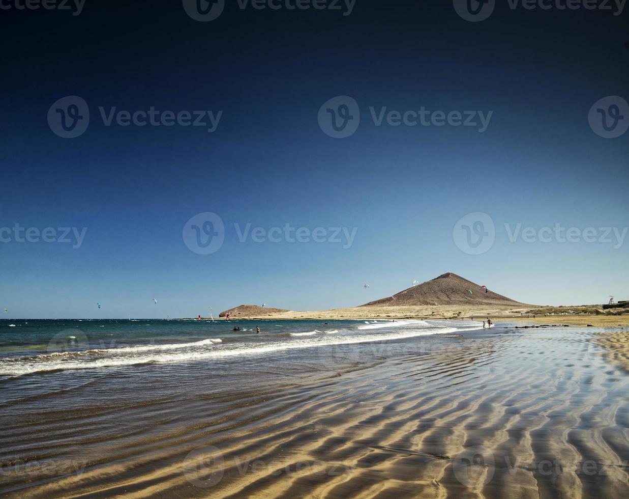 La playa turística de El Médano y el famoso paisaje de Montana Roja en Tenerife España foto