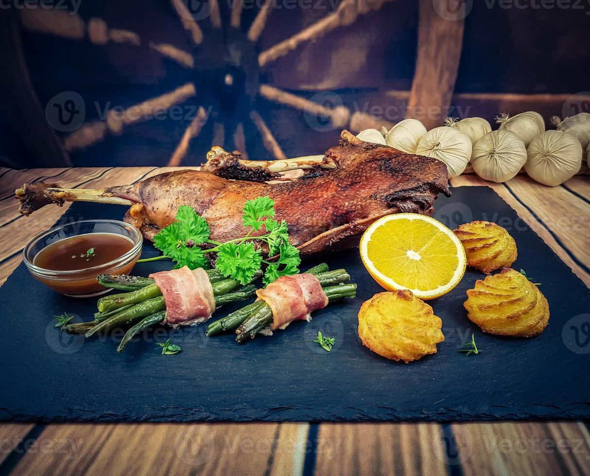 ganso asado con frijoles y patatas duquesa foto