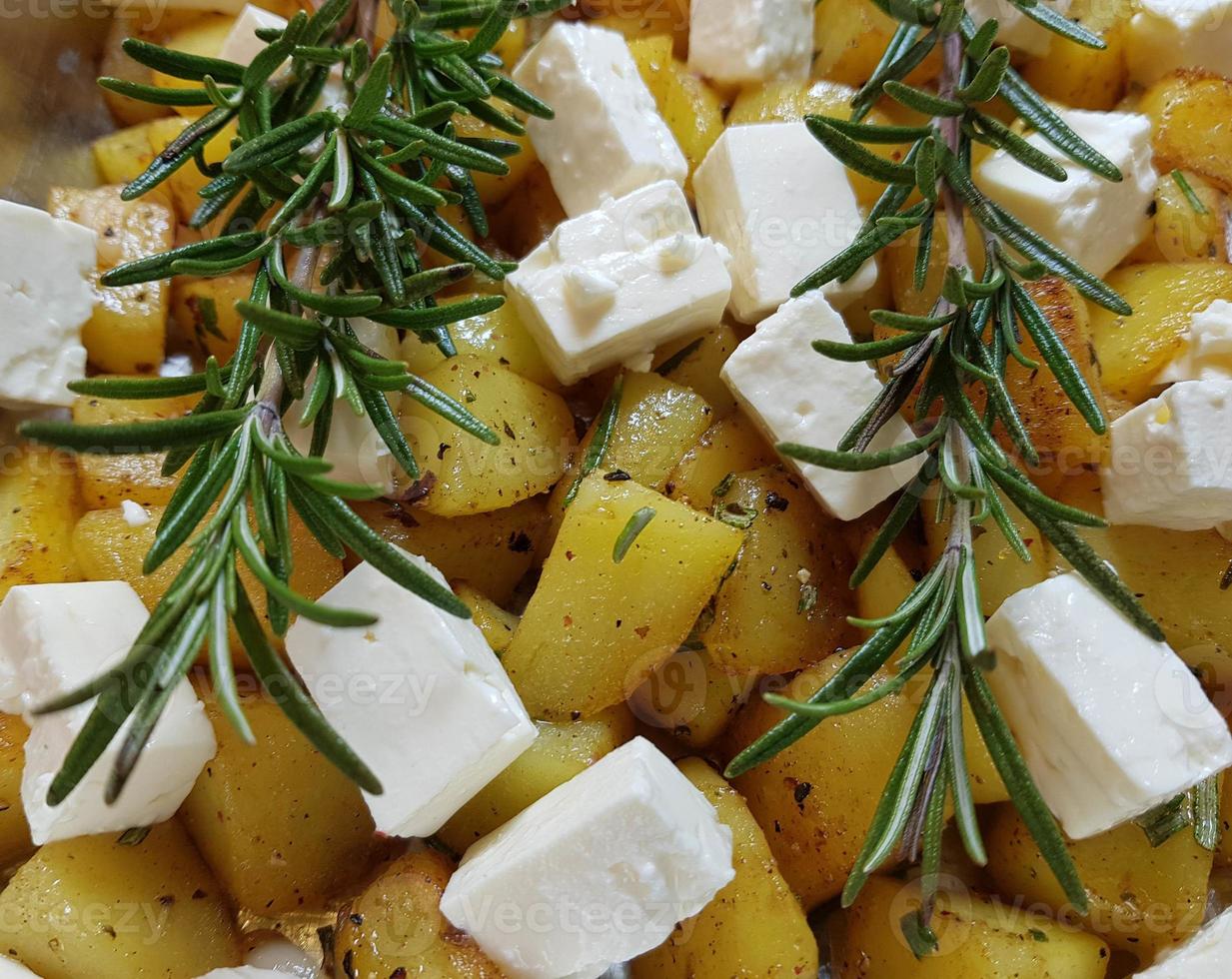 Roasted rosemary potatoes and sheep cheese with herbs and spices photo