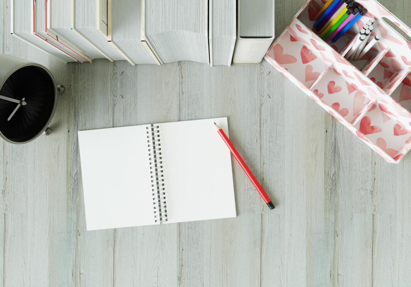 una sala de trabajo con un cuaderno, bolígrafos y relojes sobre la mesa blanca. foto