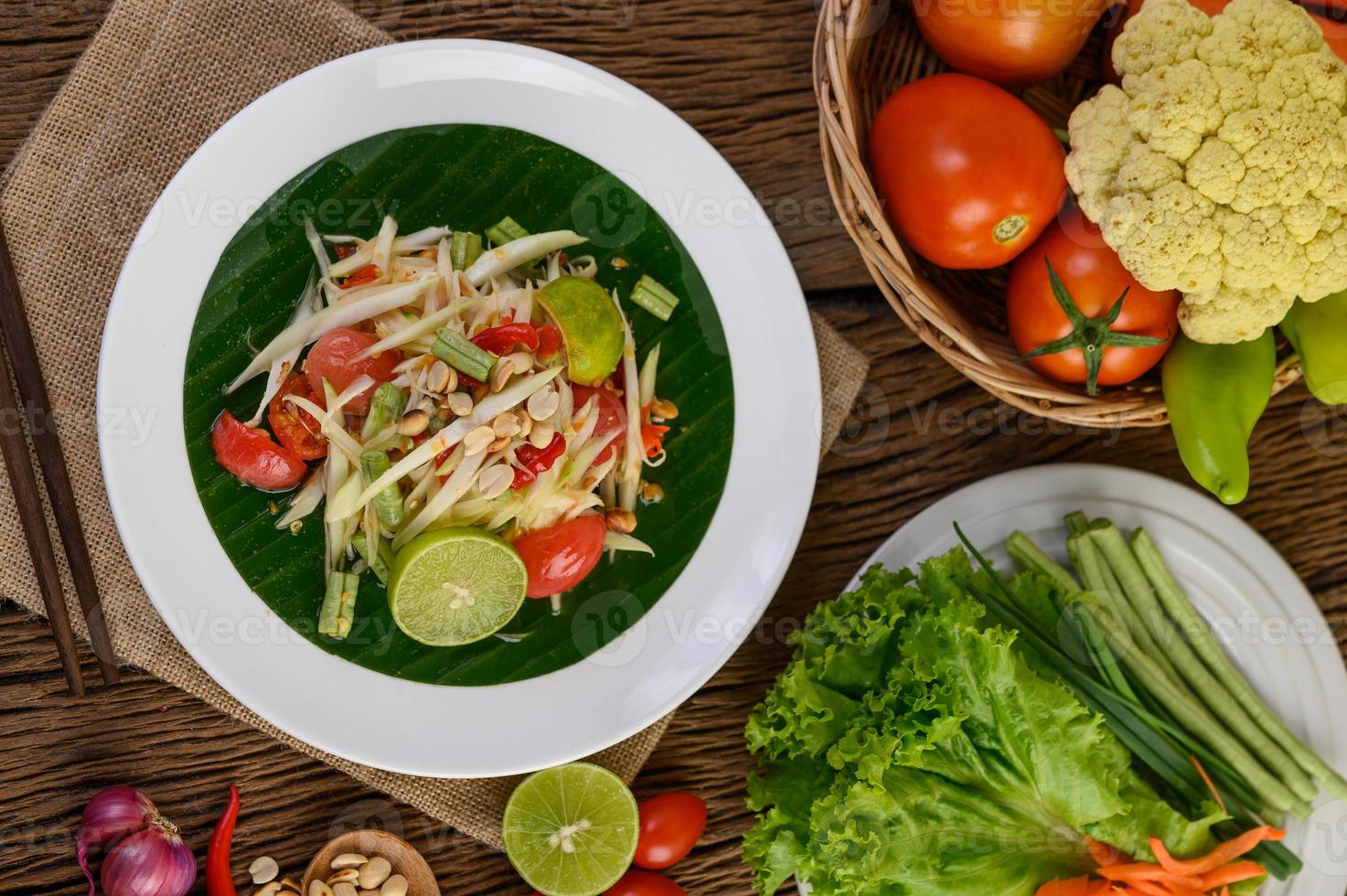 Papaya salad on a white plate on a wooden table photo