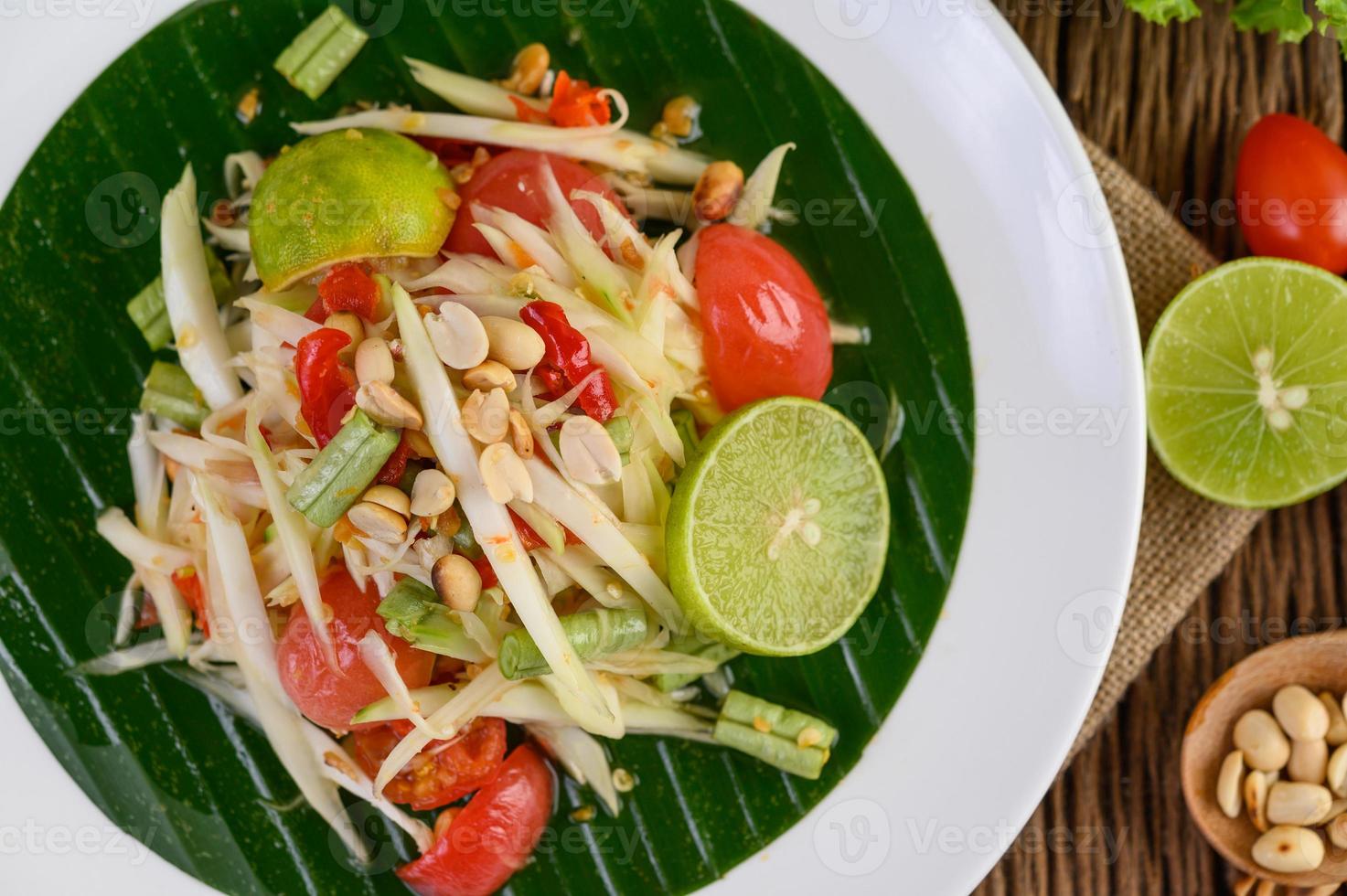 Papaya salad on a white plate on a wooden table photo