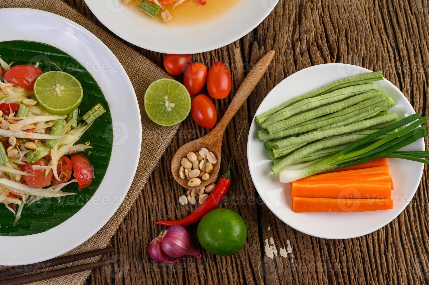 Ensalada de papaya en un plato blanco sobre una mesa de madera foto