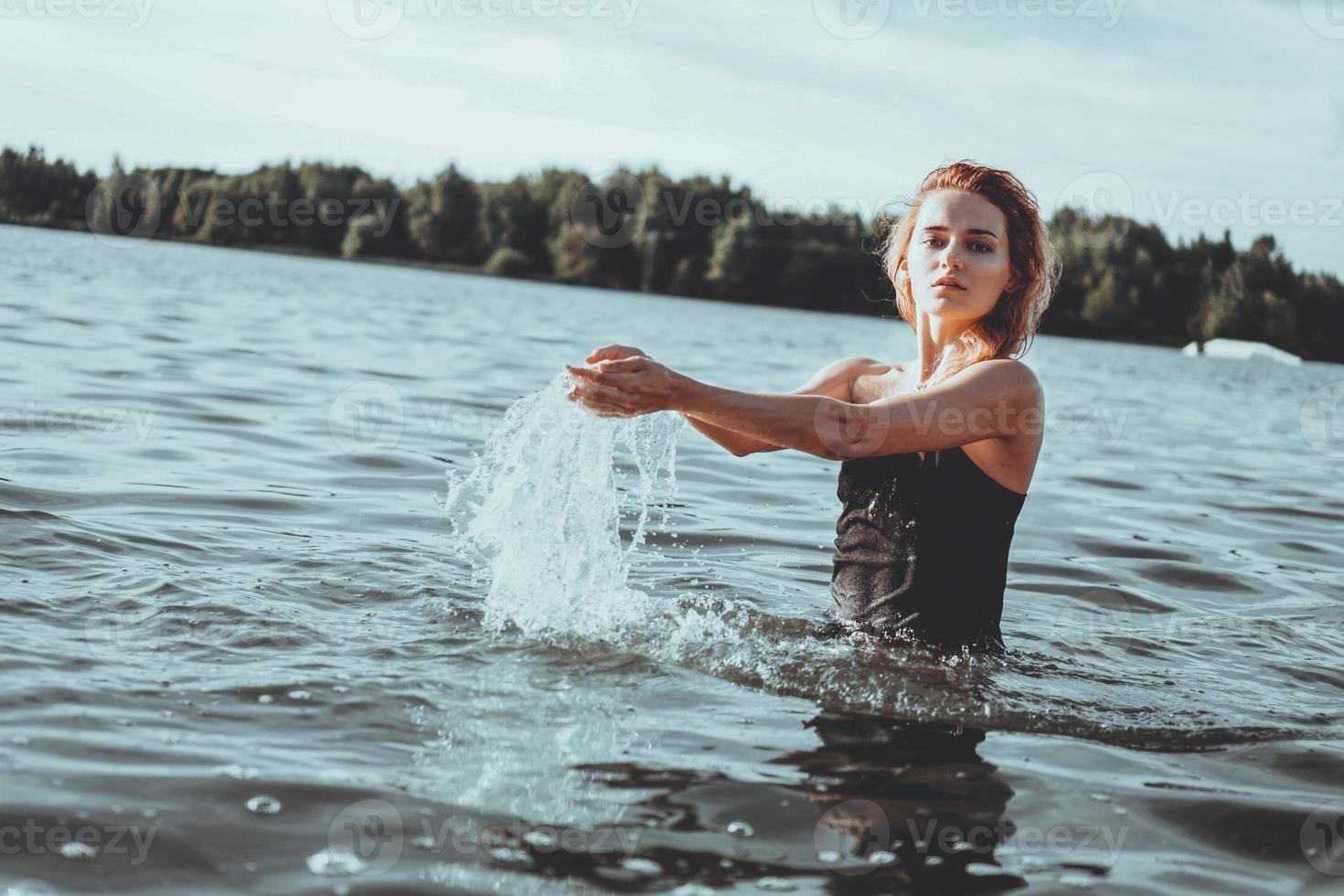 joven y bella mujer de pie en el agua. foto