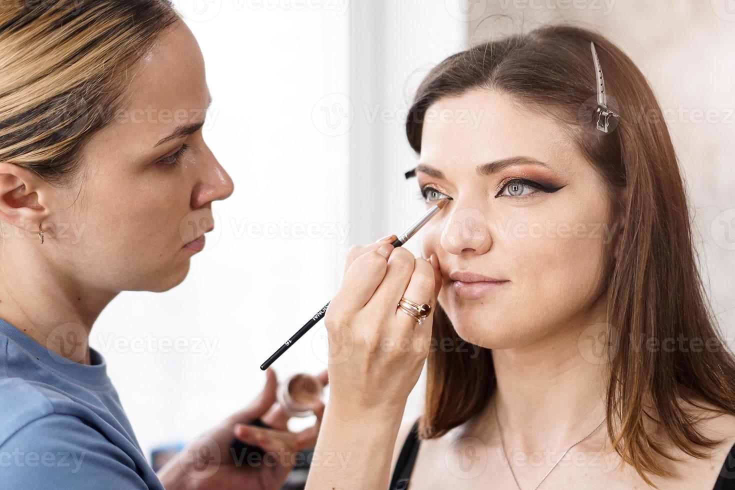 hermosa chica se maquilla en un salón de belleza foto