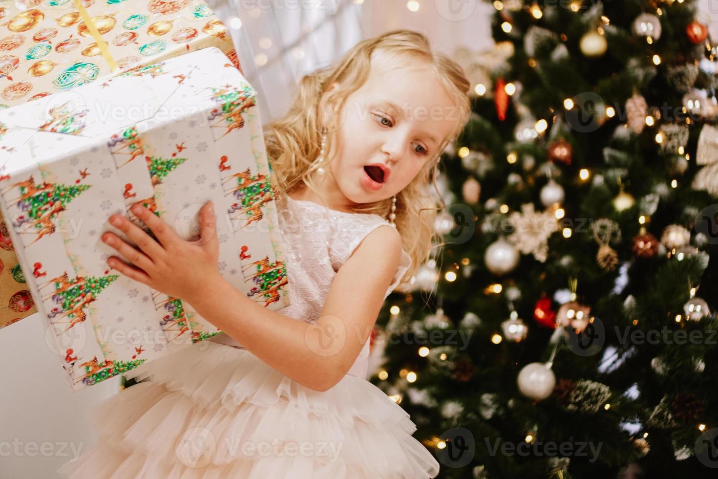 Cute little girl in pink dress with present photo