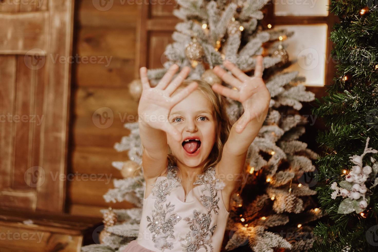 Little girl in a pink dress grimaces photo