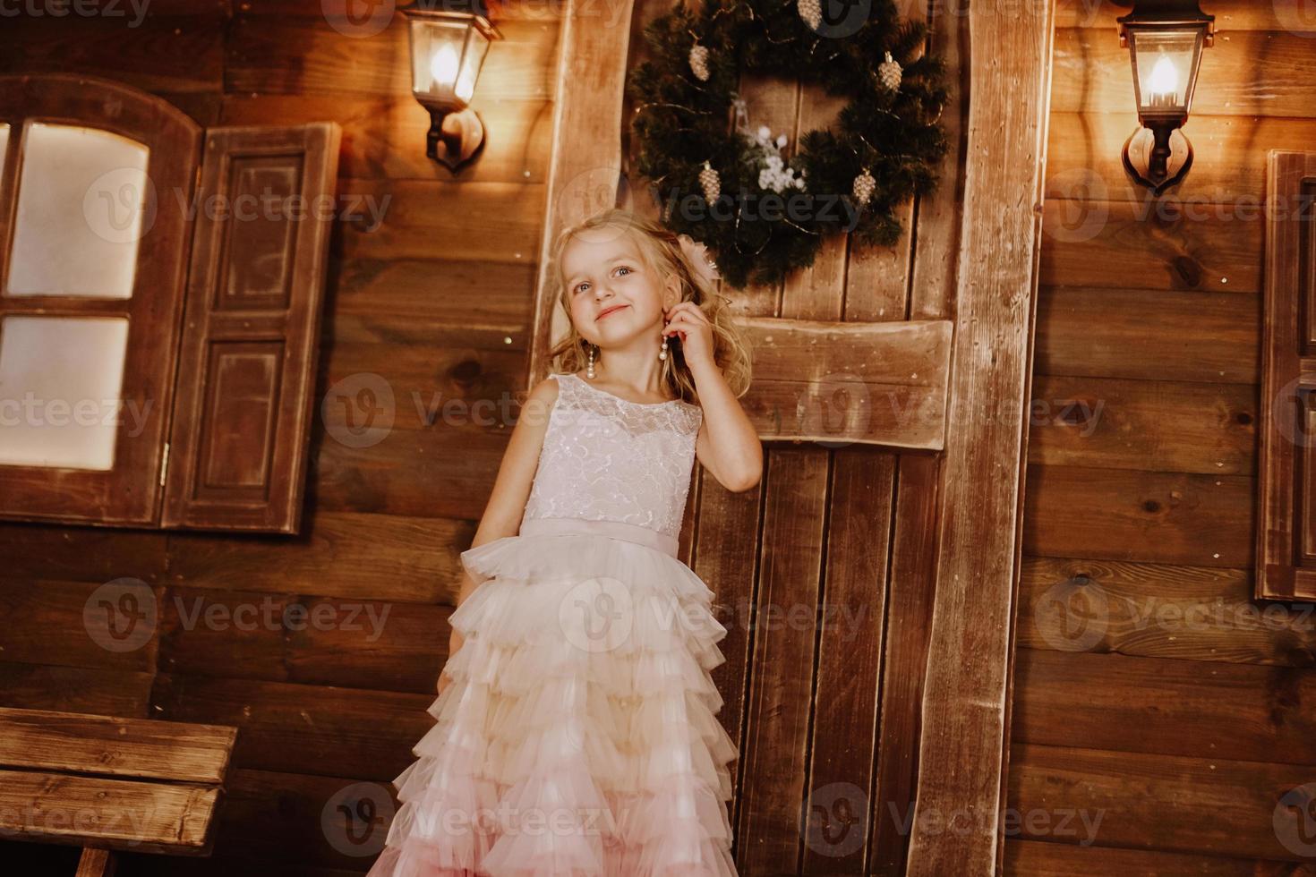 Girl with long blond hair fix earring in pink dress photo