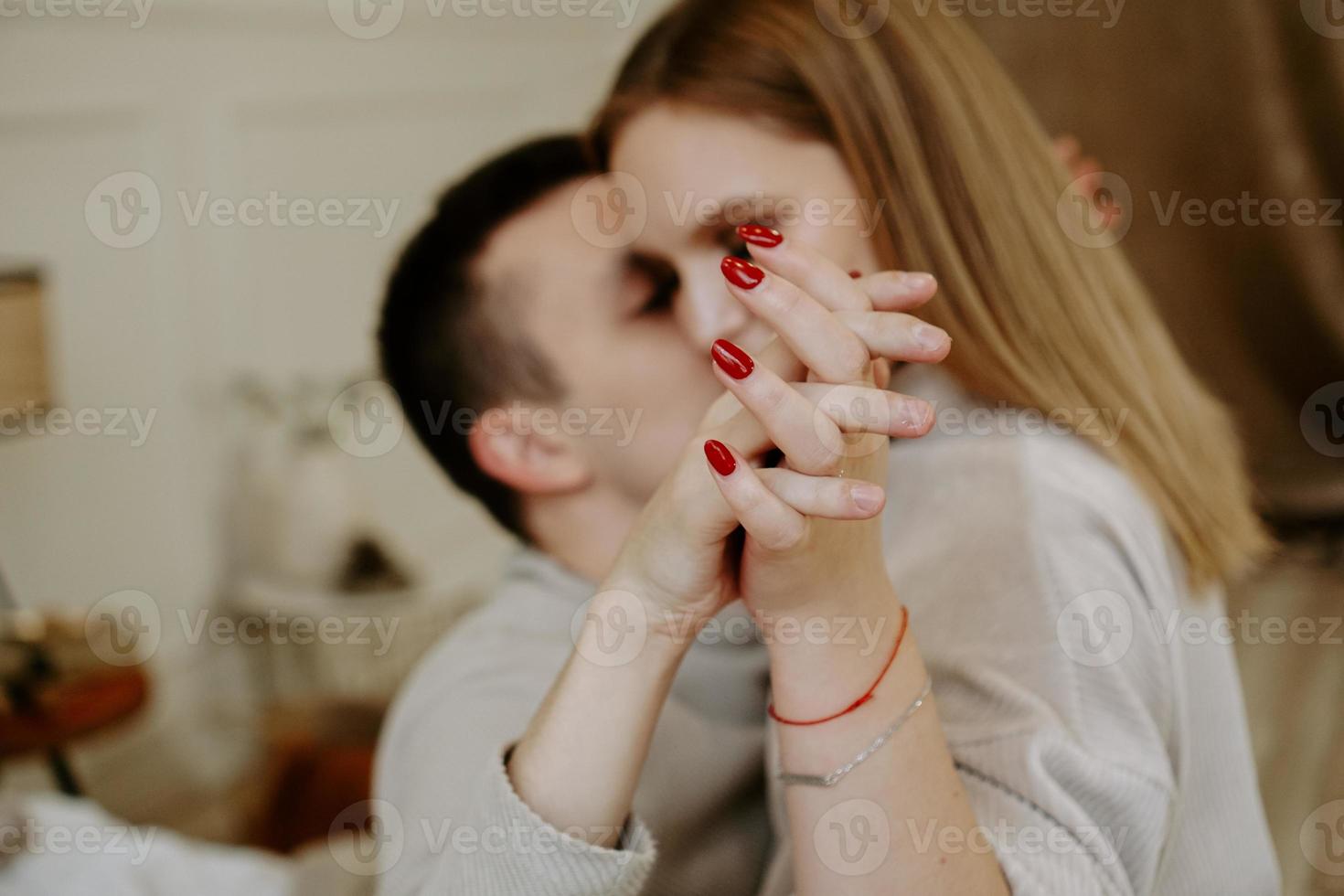 pareja tomados de la mano en la cama, los amantes se abrazan relajándose en el dormitorio foto