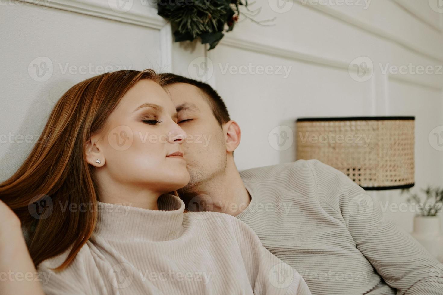 bonita pareja amorosa en la cama juntos. ellos se abrazan y sonríen foto