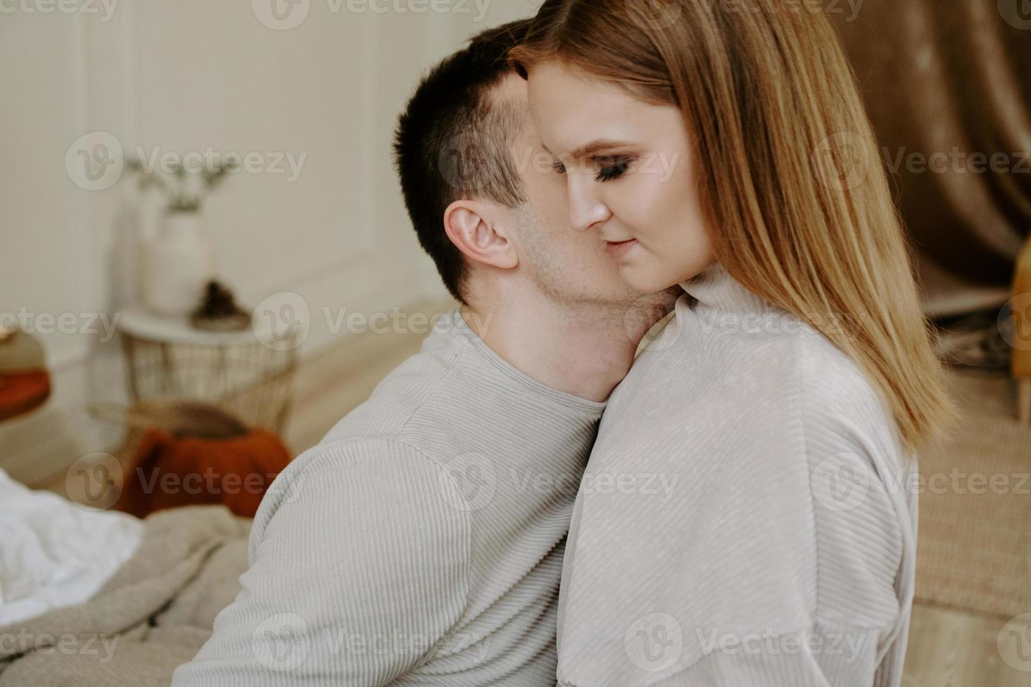 Pretty loving couple in bed together. They are hugging and smiling photo