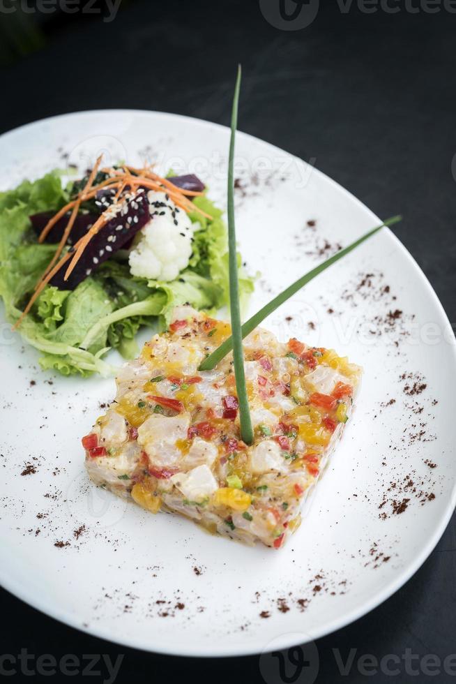 Tartar de atún crudo marinado con cocina de fusión asiática gourmet con salsa de mango tropical picante y salsa de lima foto