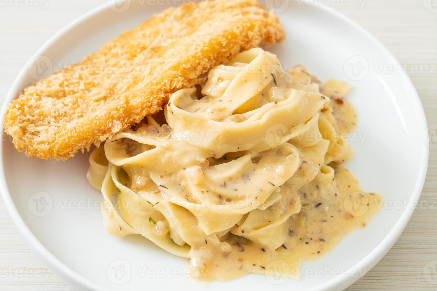 pasta fettuccine salsa de crema blanca con pescado frito foto