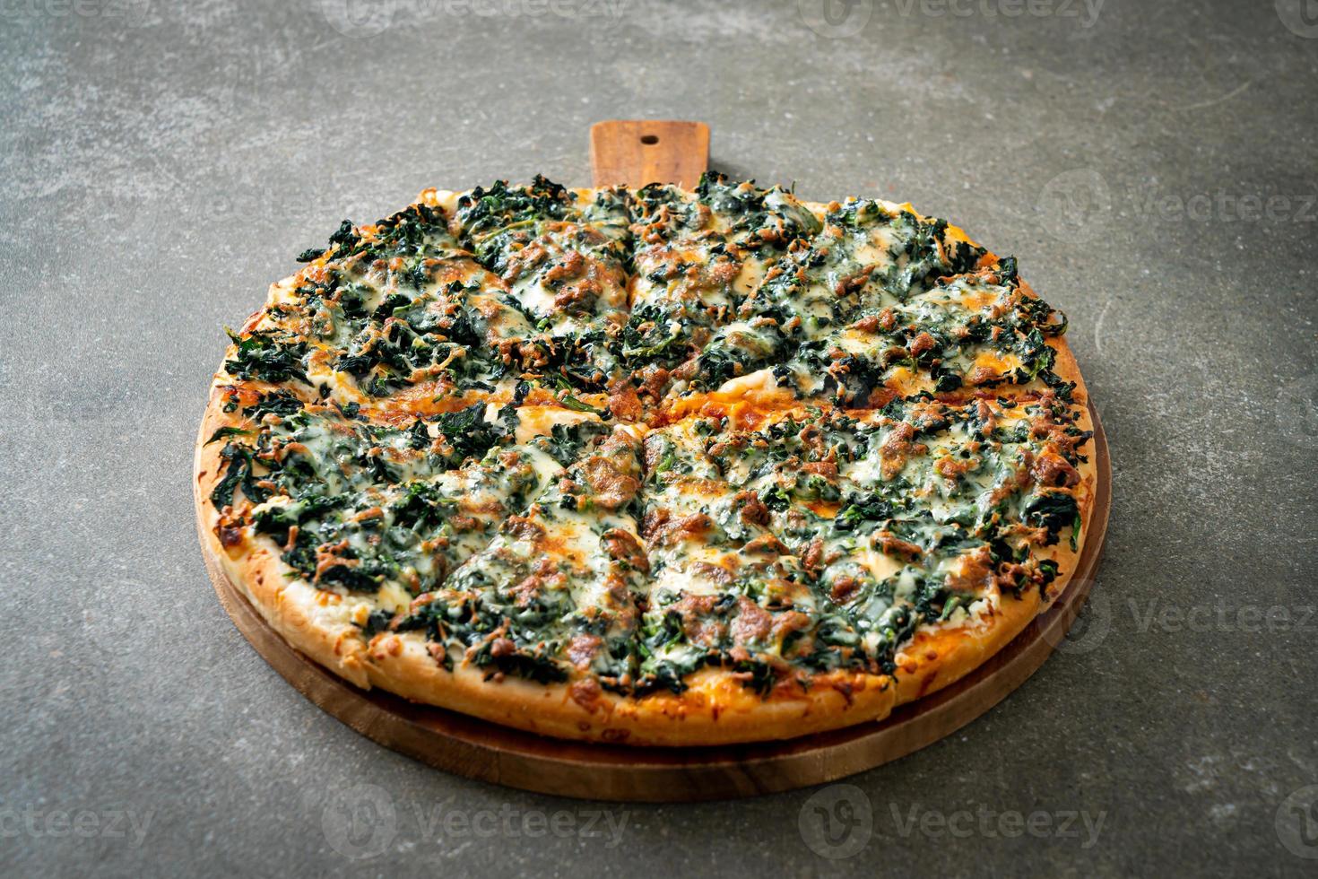 Spinach and cheese pizza on wood tray photo